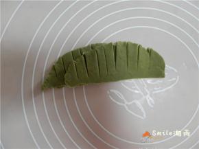 剩下的绿面团，擀成椭圆形，再切成条、从左向右叠合，整理成花朵的样子。
