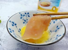 鸡蛋嗑入碗里，腌制好的鸡胸肉沾上蛋液。