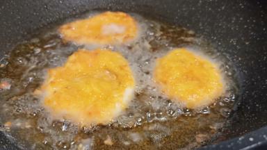 锅里加适量的油，油温5成热、鸡胸肉沿着锅边下油锅油炸。