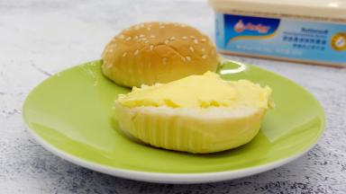 汉堡胚对半切开，抹上软黄油。