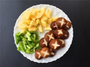 将土豆、青椒切滚刀块，香菇洗净切花。