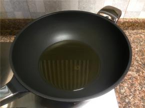热锅倒油烧至八成热。