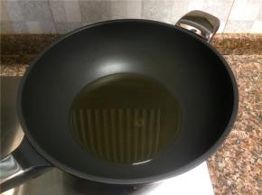 热锅倒油烧至八成热。