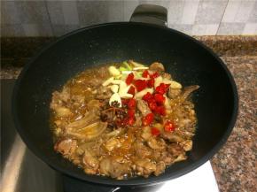 放入花椒、八角、小葱头、泡椒、大蒜、泡姜等调味菜翻炒1分钟。