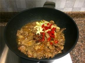 放入花椒、八角、小葱头、泡椒、大蒜、泡姜等调味菜翻炒1分钟。