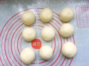 取出发酵好的面团，轻拍排气，然后揉圆，称重后将面团分割成9个均等的小剂子，滚圆后盖上保鲜膜松弛15分钟。