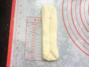 翻面后将两边向中间三分之一处对折压紧,再擀长，如图状。