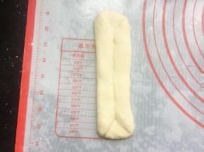 翻面后将两边向中间三分之一处对折压紧,再擀长，如图状。