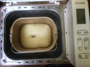 首先将除黄油以外的所有食材放入面包桶里，用筷子搅匀至没有干粉的状态，然后启动面包机开始揉面，揉至面团粗膜状态时加入软化的黄油，继续揉至完全扩展阶段，即面团光滑而有光泽，面团撑开是有韧性的薄膜状态，盖上面包机盖子，让面团在室温26度的环境下发酵至两倍大。