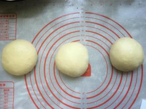 取出发酵好的面团，轻拍排气，然后揉圆，称重后将面团分割成3个均等的小剂子，滚圆后盖上保鲜膜松弛20分钟。