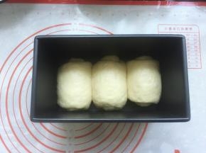 再将松弛好的面团擀开，然后翻过来，从上往下卷起，全部卷好后放入吐司盒，卷卷的方向最好一致，接着放入温度38度，湿度75%的环境下进行最后一次发酵。