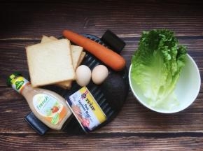 彻底凉透后用锯齿刀将吐司切成吐司片，开始准备制做三明治的食材。