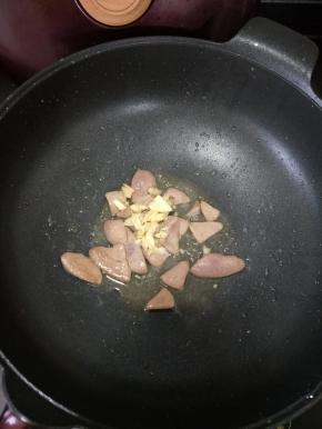 猪肝变色后加入适量盐和料酒，再放入蒜蓉，继续翻炒均匀。