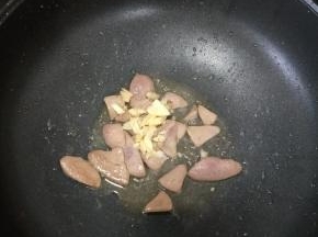 猪肝变色后加入适量盐和料酒，再放入蒜蓉，继续翻炒均匀。