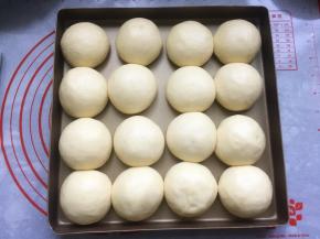 将面包胚放在温暖湿润处进行第二次发酵，面团发酵至2到2.5倍大。我是直接将装了面包胚的烤盘放在烤箱里，然后放入一碗热水进行发酵的。