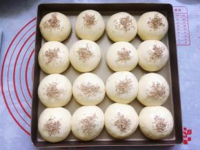 将发酵好的面包胚刷上一层薄薄的全蛋液，然后撒上少许白芝麻做装饰。