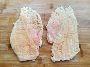 用刀背或者擀面杖敲打鸡胸肉，打断筋膜，让它变大变薄，这样腌制的时候才容易入味。