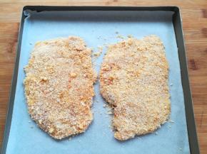 沾好面包糠的鸡排放到烤盘里摆好合适的位置。