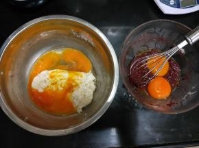 把蛋黄分别放入两种颜色的蛋糕糊里，翻拌至顺滑。