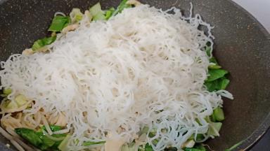 下泡好的米线，用2双筷子不停地翻炒出水份。