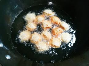 锅中放入适量食用油烧热，用左手抓肉糊，虎口挤出圆的肉糊，右手接住轻轻放入油锅中火炸，看到油下面肉糊变成浅黄翻面炸