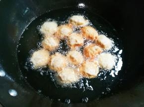 锅中放入适量食用油烧热，用左手抓肉糊，虎口挤出圆的肉糊，右手接住轻轻放入油锅中火炸，看到油下面肉糊变成浅黄翻面炸