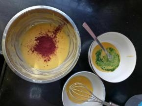 在一份50克的蛋黄糊里加入青菜泥和5克低筋面粉，翻拌均匀。另一份50克是原味的，什么都不用加，然后剩下的那份加入红曲粉，也一样翻拌均匀。