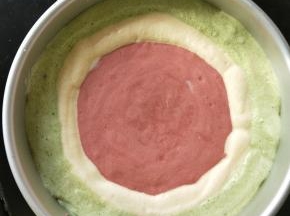 然后在模具中心加入红色蛋糕糊，每次放到和原味蛋糕糊平平的就可以。
重复原来的步骤，一直把蛋糕糊挤完，然后在垂直桌面上摔一下模具，震出里面气泡。这时候可以预热烤箱，上下130度。