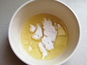 玉米油加入糖粉，用手抽先搅打均匀。
