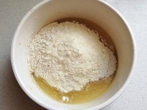 所有粉类混合均匀，加入到玉米油混合物中，先用搅拌刀把它翻拌均匀，然后揉成面团。