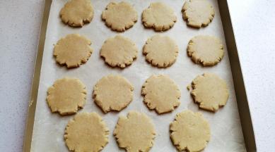 然后依次把每份小面团用手压扁摆入烤盘中。