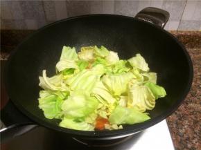 放入卷心菜翻炒1分钟，使卷心菜变软。