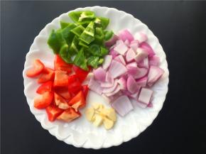 将红椒、青椒、洋葱切块，大蒜切片。