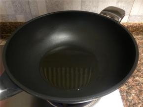 热锅倒油烧至八成热。