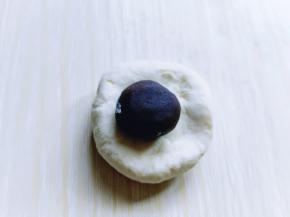 将剩下的面团分割成等份的小面团，醒5分钟，取一小块面团，放上豆沙馅，包起来，收口捏紧。依次做完！