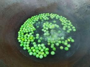 锅里烧水，水开放入少许油和少许盐，倒入豌豆米焯水两分钟。