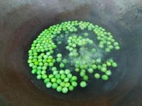 锅里烧水，水开放入少许油和少许盐，倒入豌豆米焯水两分钟。