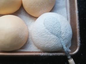 在发好的面团上可以，简单的印一些小饰物，筛上一层薄薄的高筋回粉。我用了勺子和叉子。也可以不做装饰。刷一层全蛋液，撒上芝麻椰蓉等。