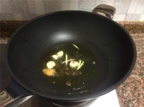 放入大蒜、生姜、小葱和花椒翻炒出香味。