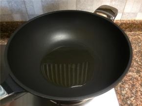 热锅倒油烧至八成热。
