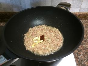 放入1勺豆瓣酱和大蒜片翻炒出香味。