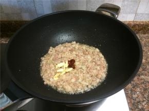 放入1勺豆瓣酱和大蒜片翻炒出香味。