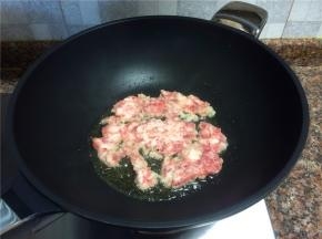 放入碎肉翻炒至变色。