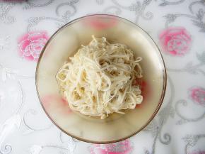 煮好的金针菇捞出，控去水分，码在深一点的盘子里