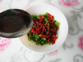 把油烧沸，看到油冒青烟的程度，舀热油浇烫在辣椒香葱碗内，大约放4汤勺油