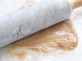 饼干放入保鲜膜中，用擀面杖压成细的粉末。