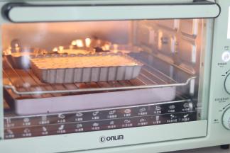 提前准备好一个装了大约一半水的烤盘，放入烤箱中，180度预热烤箱。预热好后，在装水的烤盘上层放烤架，放入模具。