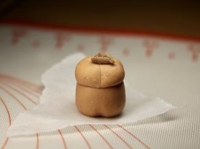 可可面团取一点，做卷边的柿子蒂，柿子顶部用无名指压一下，把柿子蒂放在顶部，牙签压一下。 
无馅的做完13个上锅冷水蒸5-7分钟。
如果做有馅的，馅7克，上下都包一点，一样操作。