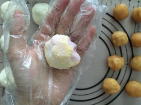 模具中裹上糯米粉，然后抖掉多余的糯米粉，包好的冰皮月饼也裹上糯米粉，放入模具中压出形状