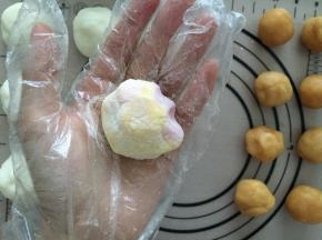 模具中裹上糯米粉，然后抖掉多余的糯米粉，包好的冰皮月饼也裹上糯米粉，放入模具中压出形状
